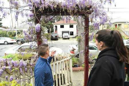 Emeryville Vice-Mayor John Bauters speaks with Joy Ashe in Emeryville, California, United States March 20, 2017. Ashe, who has spoken before the city's planning commission and city council, is concerned about pollutants from property renovations across the street from her home. To match Special Report USA-LEAD/CALIFORNIA REUTERS/Noah Berger