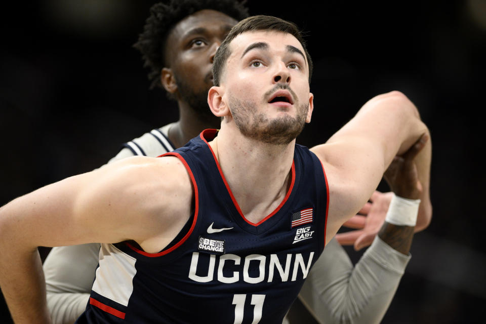 Connecticut forward Alex Karaban (11) boxes out during a foul shot in the second half of an NCAA college basketball game against Georgetown, Saturday, Feb. 10, 2024, in Washington. (AP Photo/Nick Wass)