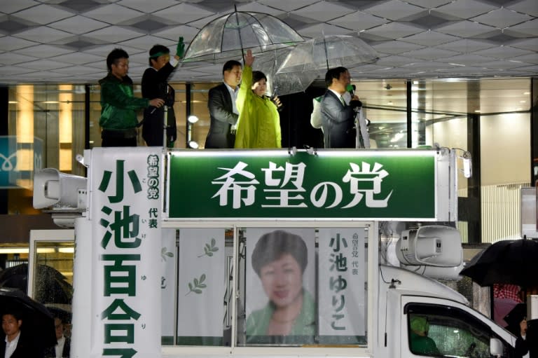 Tokyo Governor and leader of the Party of Hope Yuriko Koike (C) waves from a campaign car on the last day of campaigning for the general elections in Tokyo on October 21, 2017