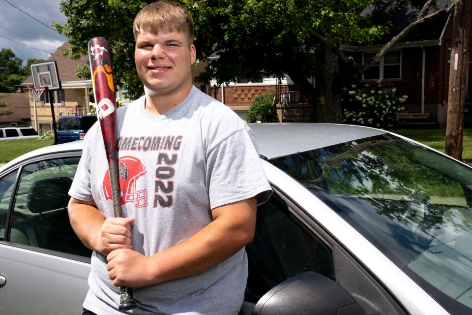 Asher Moore, an Oak Hills High School baseball and football player, poses next to his car in West Price Hill on Thursday, Aug. 10, 2023. 