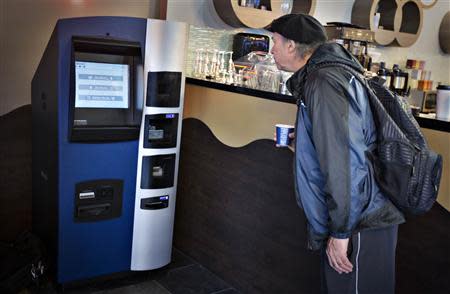 A man looks at the world's first ever permanent bitcoin ATM unveiled at a coffee shop in Vancouver, British Columbia October 29, 2013. REUTERS/Andy Clark
