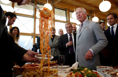 Britain's Prince Charles is offered Amatriciana pasta dish during his visit to the town of Amatrice, which was levelled after an earthquake last year, in central Italy April 2, 2017. REUTERS/Alessandro Bianchi