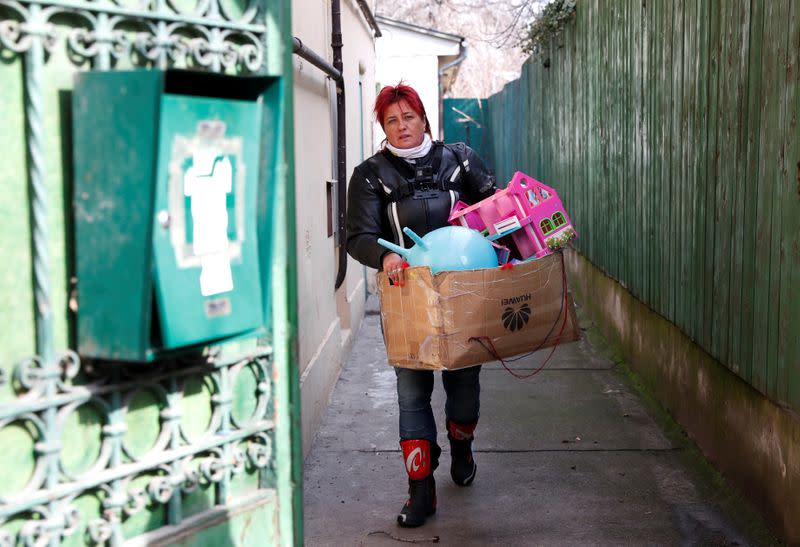 Morucz, a member of the 'Easy Riders', a Hungarian bikers group, carries the belongings of a domestic violence victim in Budapest