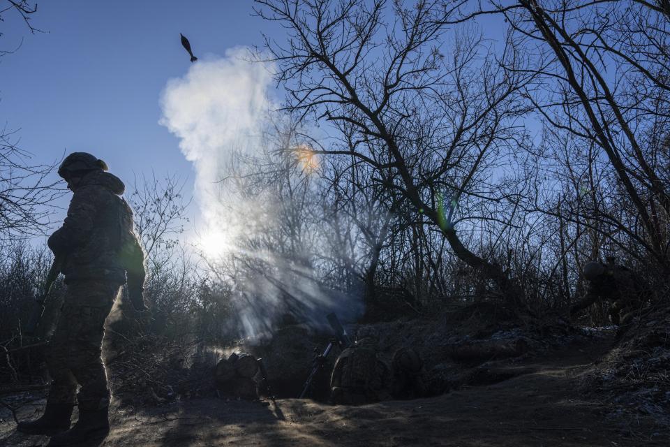 Ukrainian servicemen fire a 120 mm mortar towards Russian positions at the frontline near Bakhmut, Donetsk region, Ukraine, Wednesday, Jan. 11, 2023. (AP Photo/Evgeniy Maloletka)
