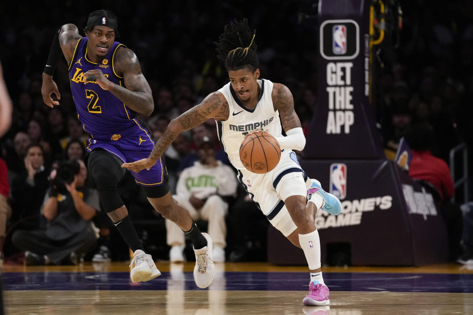 Memphis Grizzlies guard Ja Morant (12) controls the ball against Los Angeles Lakers forward Jarred Vanderbilt (2) during the first half of an NBA basketball game in Los Angeles, Friday, Jan. 5, 2024. (AP Photo/Ashley Landis)