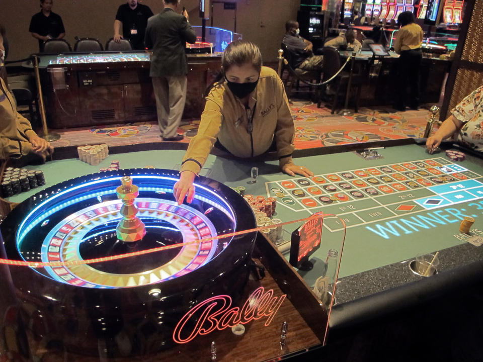 This June 23, 2021 photo shows a dealer conducting a game of roulette at Bally's casino in Atlantic City, N.J. Rhode Island-based Bally's Corp. is spending $100 million on renovations to the property, which ranks last among Atlantic City's nine casinos in terms of gambling revenue. (AP Photo/Wayne Parry)