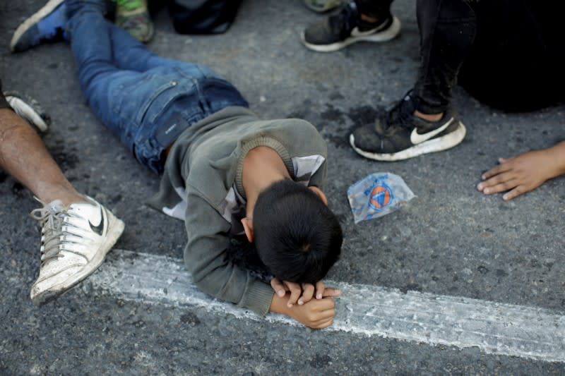 Migrants, mainly from Central America and marching in a caravan, rest on a road near Ignacio Zaragoza, Chiapas