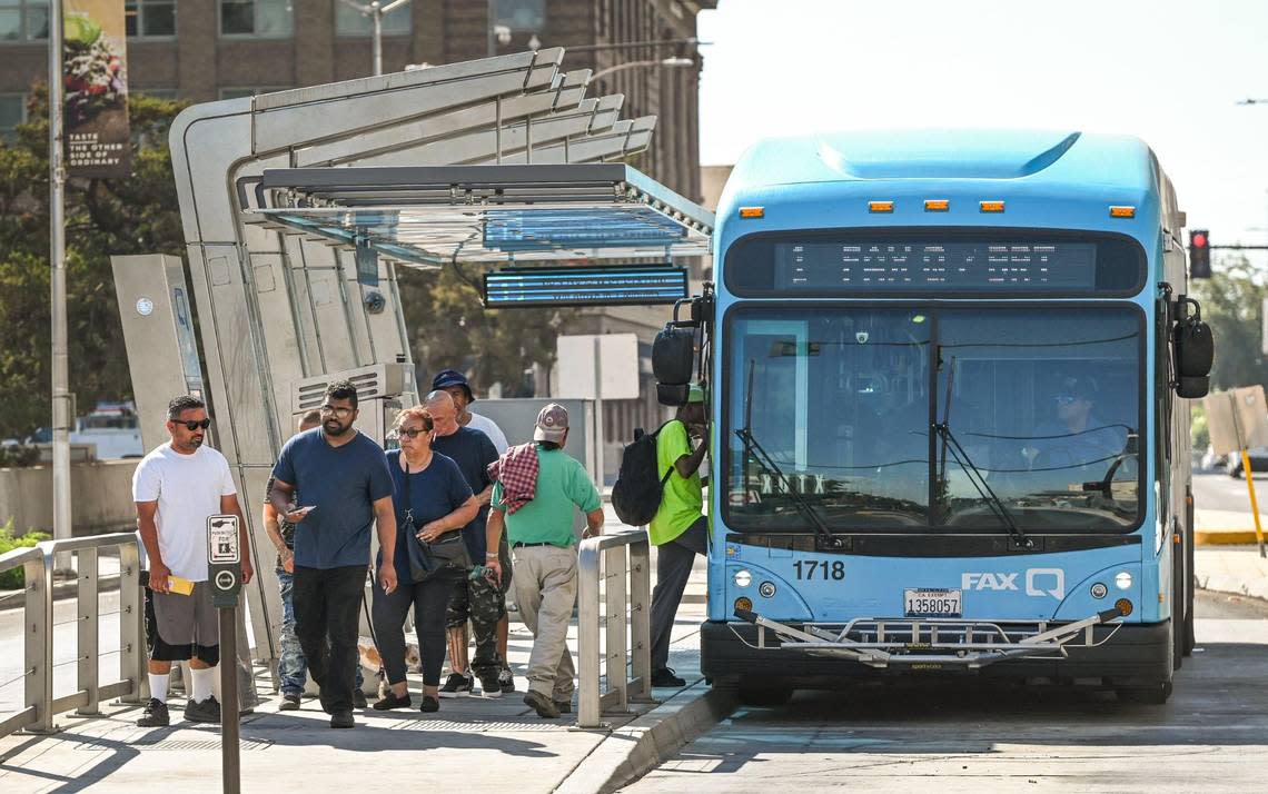 Riders get on and off a Fresno FAX bus after pulling into the Downtown Transit Center on Van Ness Avenue in front of the Fresno County Courthouse on Tuesday, Aug. 15, 2023.