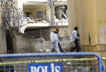 Turkish police forensic experts carry out an examination near a building damaged by a truck bomb attack on a police station, in Cinar in the southeastern city of Diyarbakir, Turkey, January 14, 2016. REUTERS/Sertac Kayar