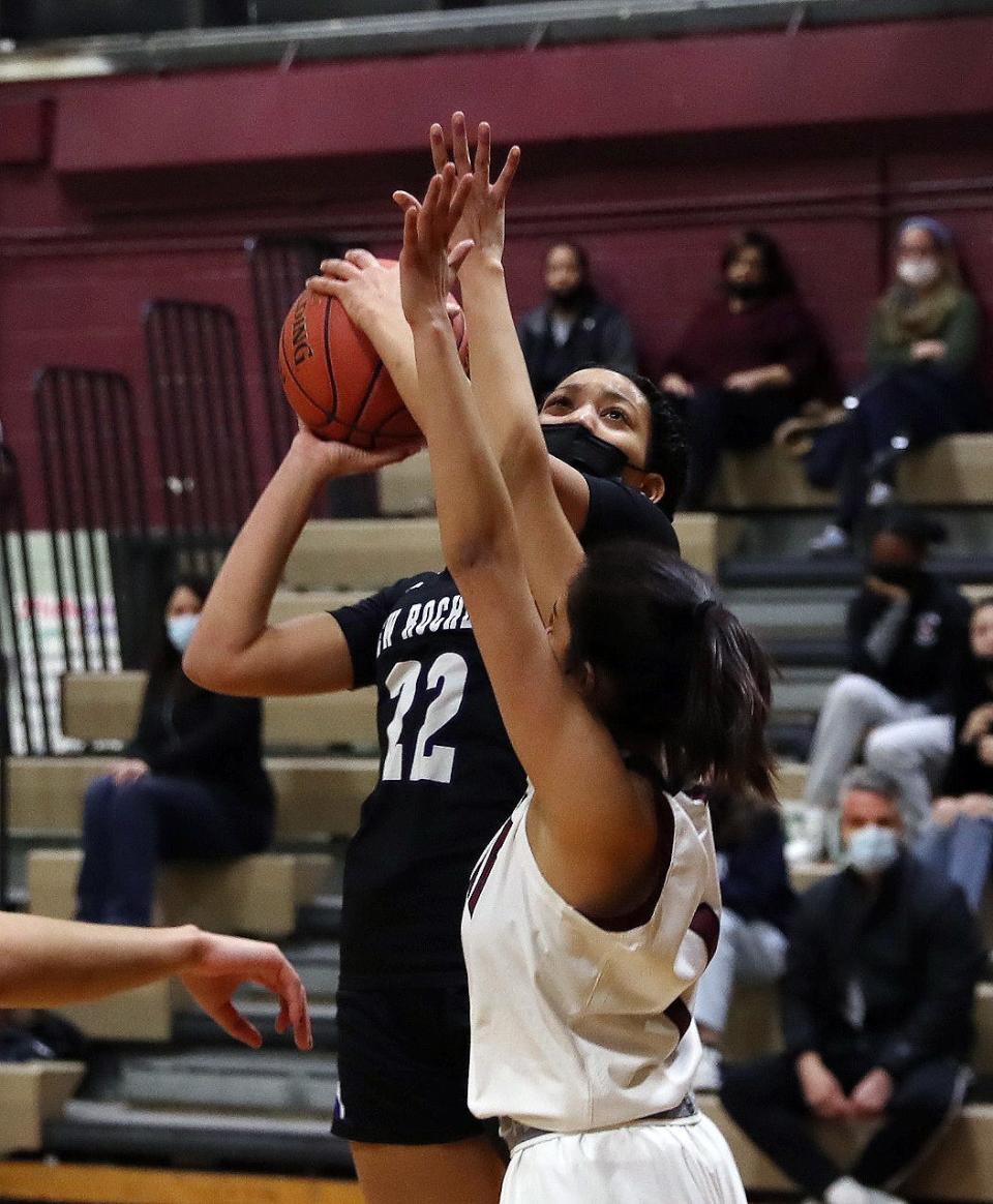 New Rochelle's Kamara St. Paul (22) puts up a shot in front of Ossining's Michelle Mercardo (1) during girls basketball action at Ossining High School on Thursday. New Rochelle won the game.