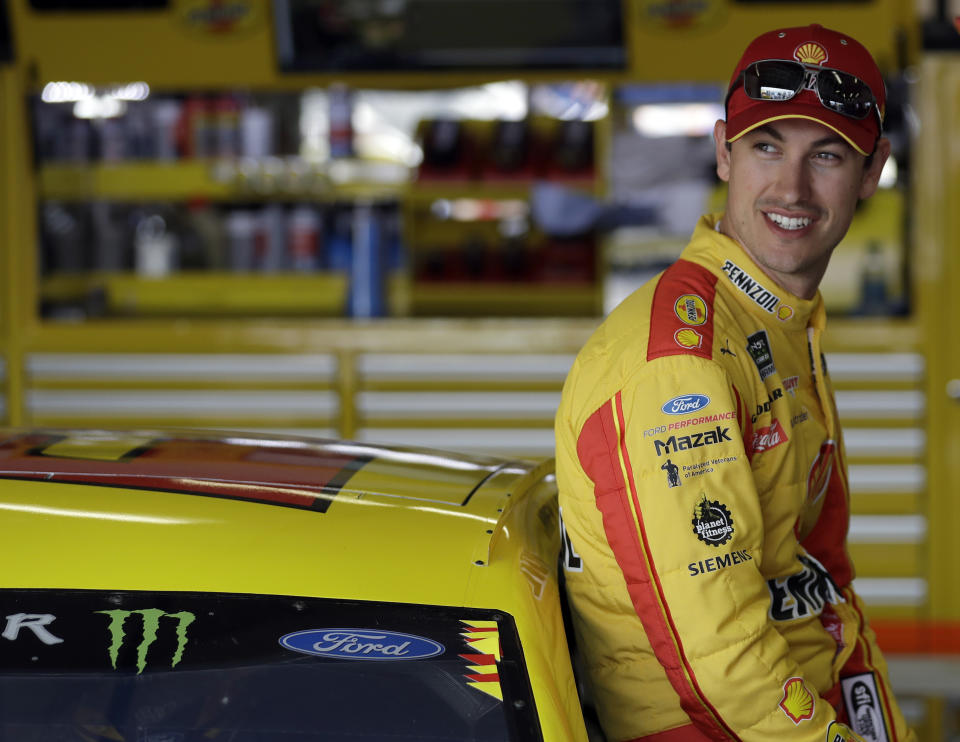 Joey Logano smiles as he talks to members of his crew during practice for the NASCAR Daytona 500 auto race, Saturday, Feb. 16, 2019, at Daytona International Speedway in Daytona Beach, Fla. (AP Photo/Chris O'Meara)