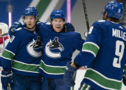 Vancouver Canucks right wing Brock Boeser (6) celebrates his goal against the Montreal Canadiens with Elias Pettersson (40) and J.T. Miller (9) during the second period of an NHL hockey game Wednesday, Jan. 20, 2021, in Vancouver, British Columbia. (Jonathan Hayward/The Canadian Press via AP)