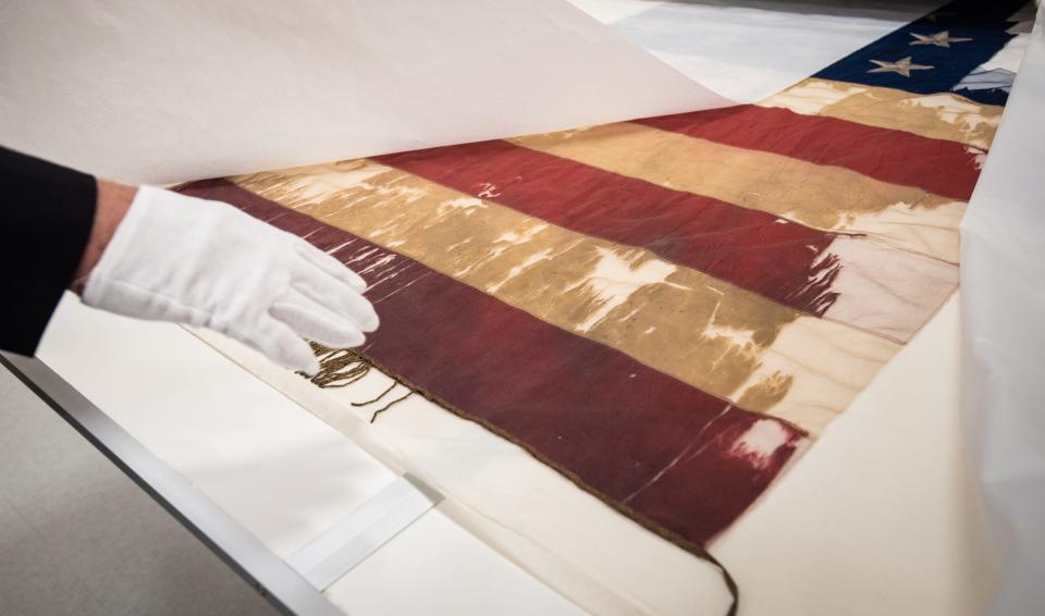 Matt Van Acker, director for the Michigan Capitol Tour Service and curator of Save The Flags, points out blood stains on a Michigan Civil War regiment battle flag Friday, Sept. 29, 2023. It is one of the 240 battle flags in the state's collection housed at the Michigan History Museum in Lansing. They are stored in a highly controlled environment to mitigate any further degradation from light, humidity, and temperature changes.