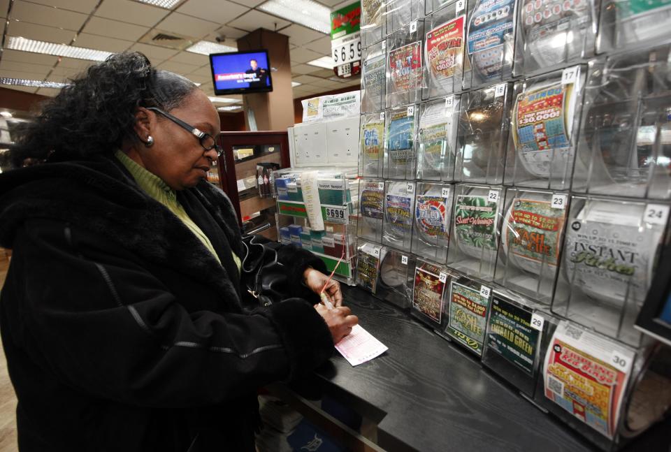 Donna Fields picks her Powerball numbers in Detroit, Wednesday, Nov. 28, 2012. Fields picked two sets of numbers off the top of her head and two easy picks in tonight's Powerball total with an estimated 500 million dollar jackpot. Fields said, "If I won I would take care of God first, then my family and do some traveling, and oh yeah, quit my job." (AP Photo/Paul Sancya)