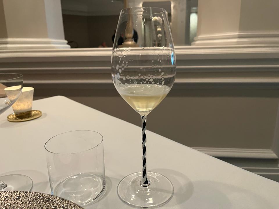 long-steamed wine glass filled with welcome drink at victoria and alberts in disney world