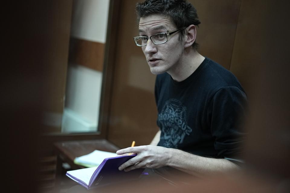 U.S. citizen Robert Woodland Romanov sits in a cage prior to a court session on drug-related charges in Moscow, Russia, Monday, April 15, 2024. Romanov is facing charges of trafficking large amounts of illegal drugs as part of an organized group — a criminal offense punishable by up to 20 years in prison. (AP Photo/Alexander Zemlianichenko)