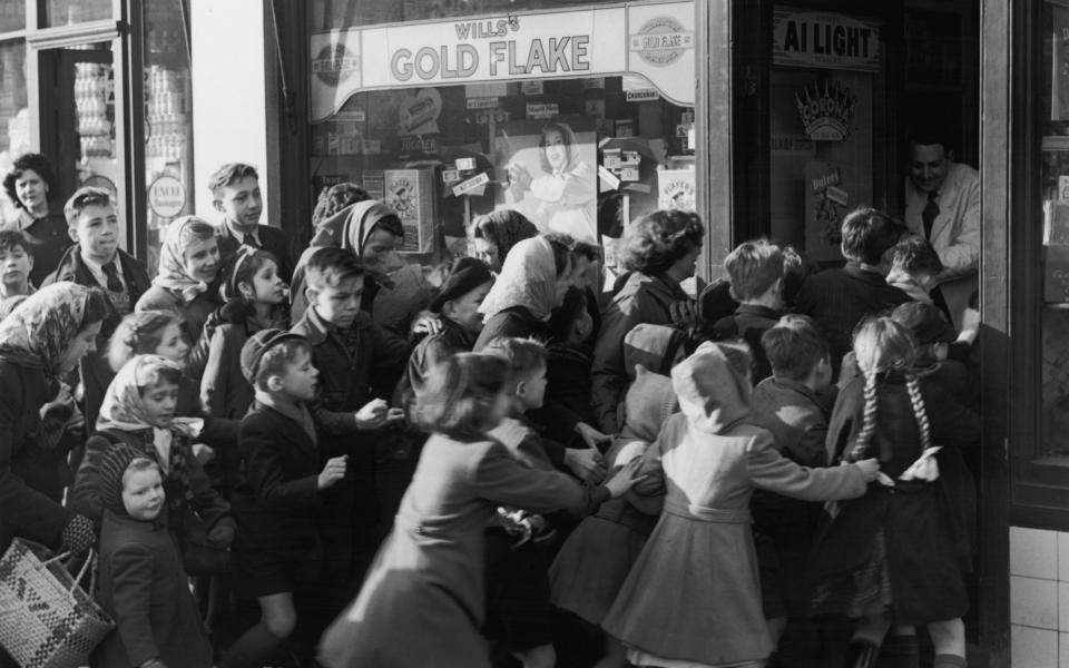 A crowd of children rush to get into a sweetshop on the day sweet rationing ended