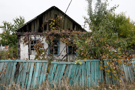 A residential house, damaged during fighting between Ukrainian troops and rebels, stands amongst overgrown plants near Donetsk airport, Ukraine, October 24, 2017. REUTERS/Alexander Ermochenko