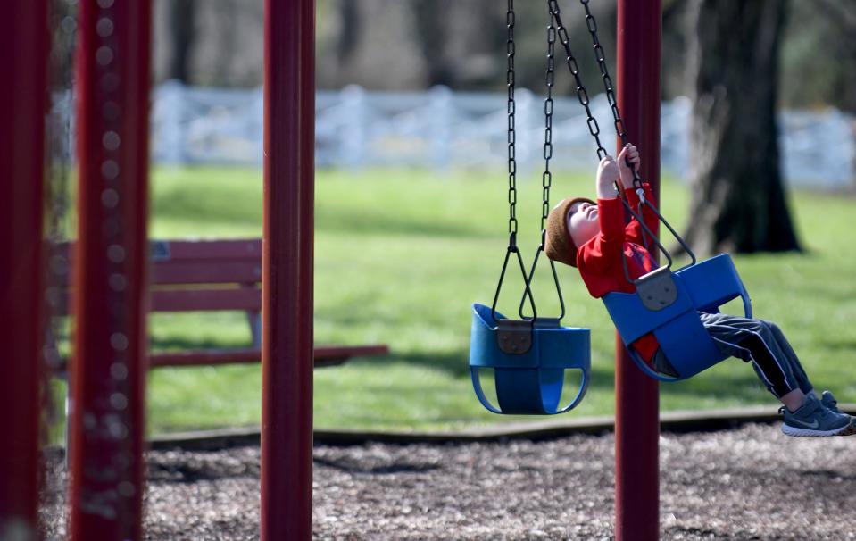 Myles McCallion, 3, swings on a warm, sunny afternoon last week at Price Park in North Canton.