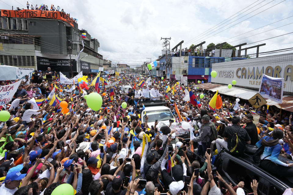ARCHIVO - El candidato presidencial de la oposición venezolana Edmundo González y la líder opositora María Corina Machado subidos a un camión con el que avanzan entre la multitud en un acto político en Barinas, Venezuela, el 6 de julio de 2024. (AP Foto/Ariana Cubillos, Archivo)