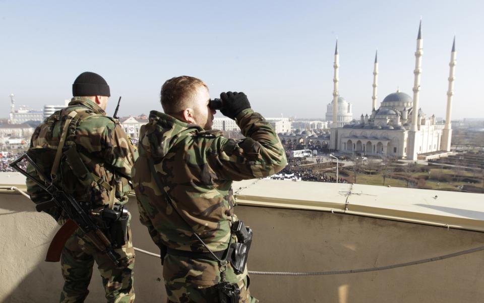 Members of law enforcement forces stand guard during a rally to protest against satirical cartoons of prophet Mohammad, in Grozny, Chechnya