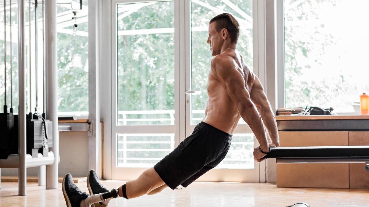  A photo of a man doing tricep dips on a bench. 