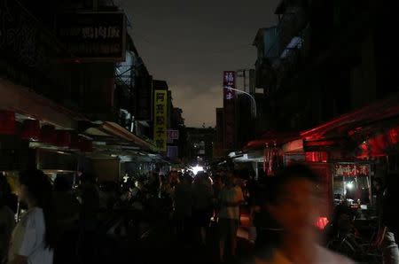 People walk on a street during a massive power outage in Taipei, Taiwan August 15, 2017. REUTERS/Stringer