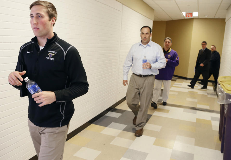 Minnesota State, Mankato football player Sam Thompson left, associate head coach Aaron Keen and coach Todd Hoffner coach arrive for a news conference Thursday, April 17, 2014, in Mankato, Minn. Players ended their boycott of spring practice and said Thursday they will play for Hoffner, who was reinstated after being exonerated of having child pornography on his cellphone. (AP Photo/Star Tribune, Jerry Holt) ST. PAUL OUT MINNEAPOLIS-AREA TV OUT MAGS OUT