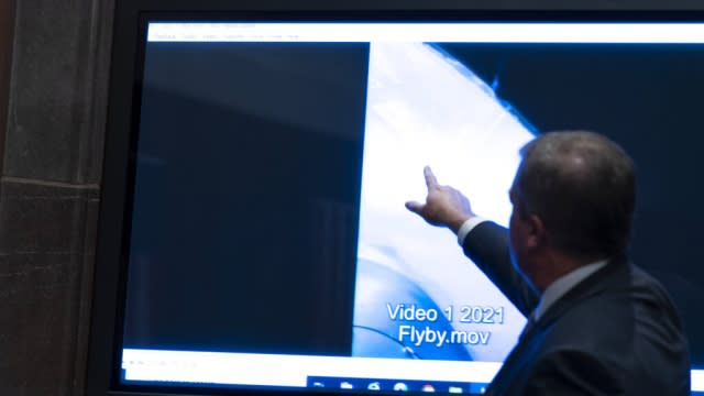 Deputy Director of Naval Intelligence Scott Bray points to a video display of a UAP.
