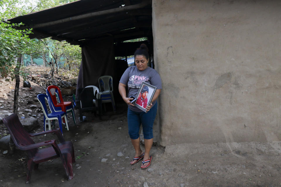 Norma Espinoza holds a portrait of her son Angel Maradiaga, at her home in Olanchito, Honduras, Saturday, May 13, 2023. Maradiaga, 17, who was detained at a facility in Safety Harbor, Florida, died Wednesday. Epinoza is demanding answers from American officials, saying her son had no known illnesses and had not shown any signs of being sick before his death. (AP Photo/Delmer Martinez)