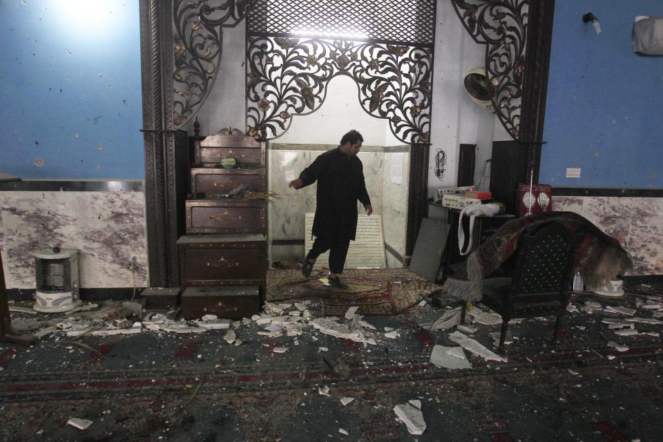 A man looks at the debris and damage after an explosion in a Shi'ite mosque in Peshawar