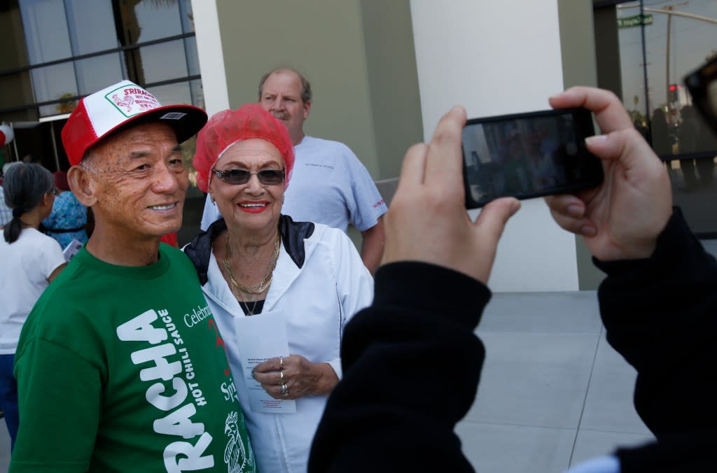 David Tran, left, has his picture taken with a visitor touring the Huy Fong Foods factory in Irwindale in 2014.