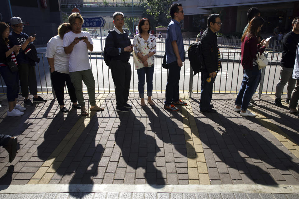 People line up to vote outside of a polling place in Hong Kong, Sunday, Nov. 24, 2019. Long lines formed outside Hong Kong polling stations Sunday in elections that have become a barometer of public support for anti-government protests now in their sixth month. (AP Photo/Ng Han Guan)