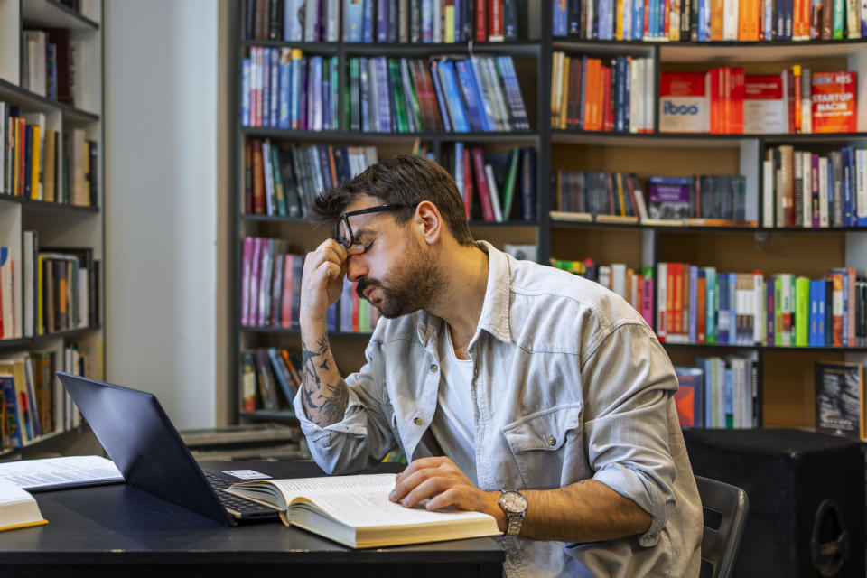 A man looks stressed in the library