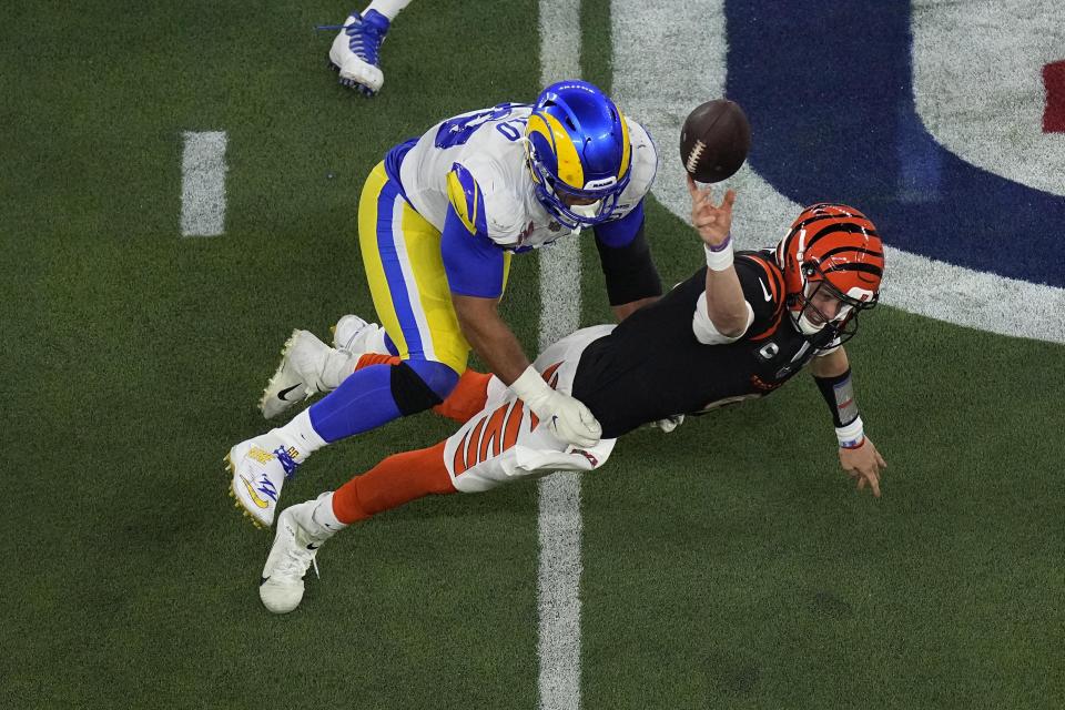 Los Angeles Rams defensive end Aaron Donald (99) forces Cincinnati Bengals quarterback Joe Burrow (9) to throw an incomplete pass during the second half of the NFL Super Bowl 56 football game Sunday, Feb. 13, 2022, in Inglewood, Calif. (AP Photo/Matt Rourke)