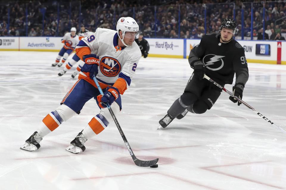 New York Islanders' Brock Nelson avoids a check from Tampa Bay Lightning's Mikhail Sergachev, of Russia, during the first period of an NHL hockey game Saturday, Feb. 8, 2020, in Tampa, Fla. (AP Photo/Mike Carlson)