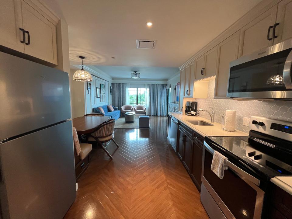 kitchen and dining room looking out into the living room of a one bedroom villa in disney's riviera resort