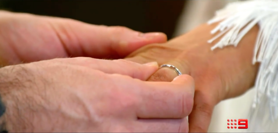 A man putting a wedding ring onto a woman's finger from Married At First Sight 2022