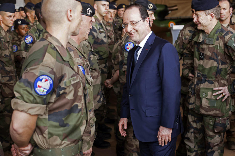 French president Francois Hollande, center, greets French troops as he arrives at the French military operation headquarters at M'Poko airport in Bangui, Central African Republic, Friday, Feb. 28, 2014. It is Hollande's second trip to Bangui since the beginning of Operation Sangaris in December. Thousands of international troops dispatched to volatile Central African Republic are there to help keep the country from breaking apart, France's president said Friday, days after the French parliament voted to prolong the country's mission in its former colony wracked by violence between Christians and Muslims. (AP Photo/Frederic Lafargue)