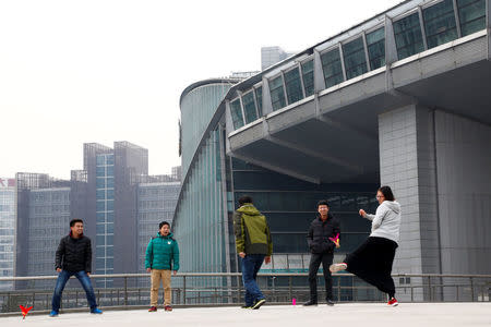 People kick a shuttlecock outside the headquarters of the New Oriental Education & Technology Group in Beijing, China, November 25, 2016. REUTERS/Thomas Peter