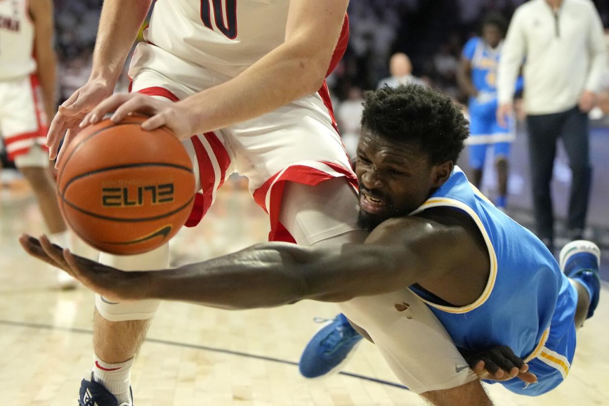 UCLA forward Adem Bona dives for the ball behind Arizona forward Azuolas Tubelis.