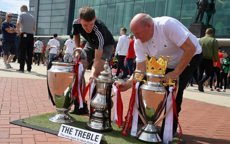 United fans with trophies - Reuters