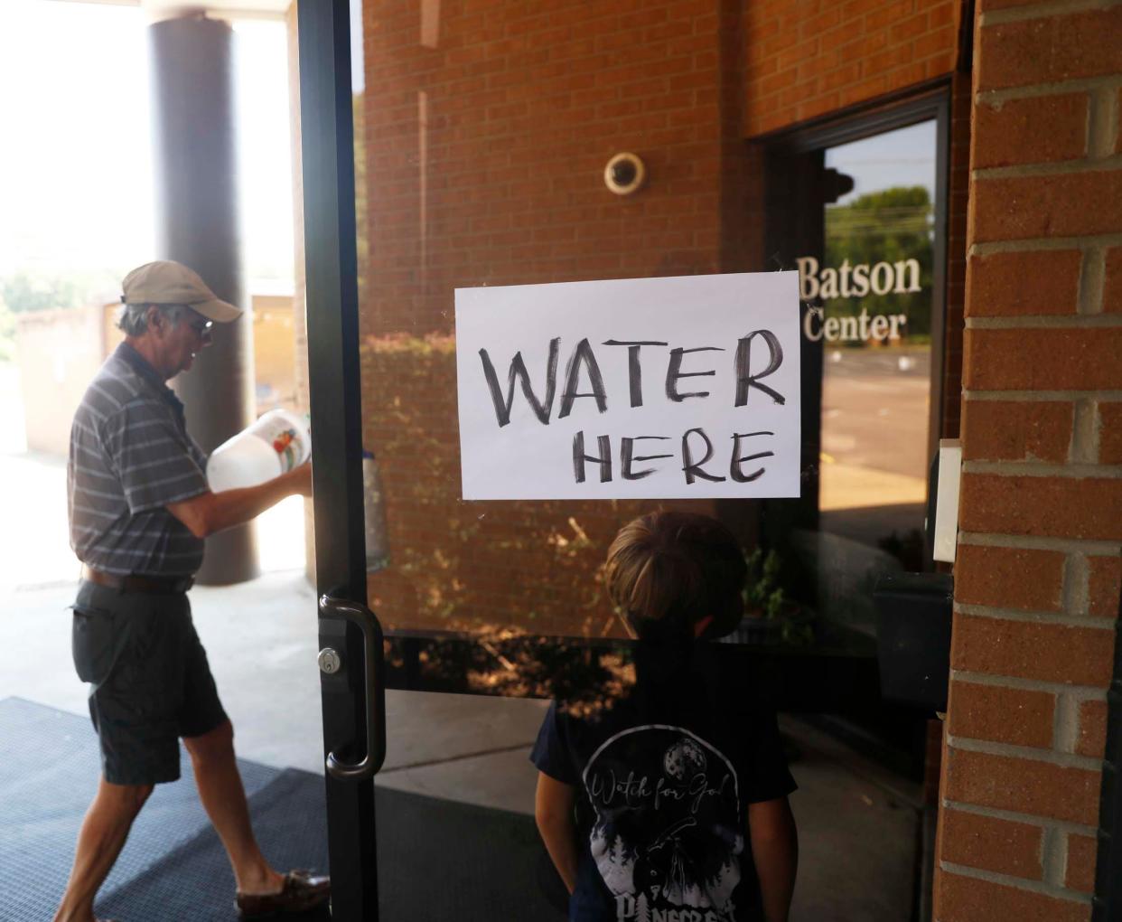 Knights of Columbus member Juan Kindelan carries an empty bottle into the Church of the Holy Spirit in Memphis to fill it with fresh, clean water for a Germantown resident amid the water crisis on July 27, 2023.