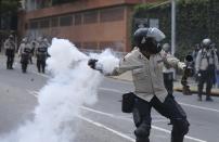 A Bolivarian National Police throw a teargas bomb toward demonstrators during a protest in Caracas, Venezuela, Saturday, April 8, 2017. Opponents of President Nicolas Maduro protest on the streets of Caracas on Saturday as part of a week-long protest movement that shows little sign of losing steam. (AP Photo/Fernando LLano)