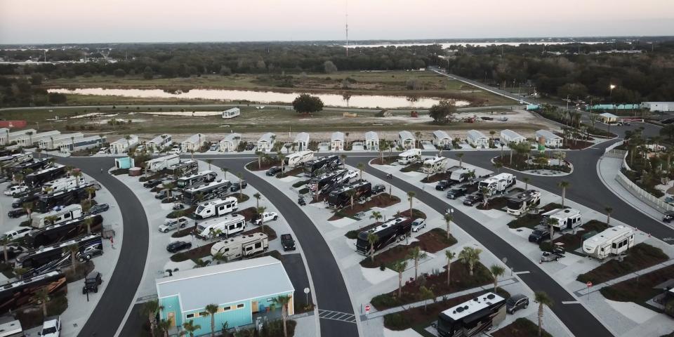 A bird's eye view of Camp Margaritaville RV Resort and Cabana Cabins in Auburndale, Florida at sunset. There are rows of parked RVs and cabins.