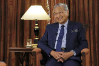 Malaysia's Prime Minister Mahathir Mohamad is interviewed in Putrajaya, Malaysia, Monday, Aug. 13, 2018. Mahathir said he will seek to cancel multibillion-dollar Chinese-backed infrastructure projects that were signed by his predecessor as his government works to dig itself out of debt, and he blasted Myanmar’s treatment of its Rohingya minority as "grossly unjust." (AP Photo/Yam G-Jun)