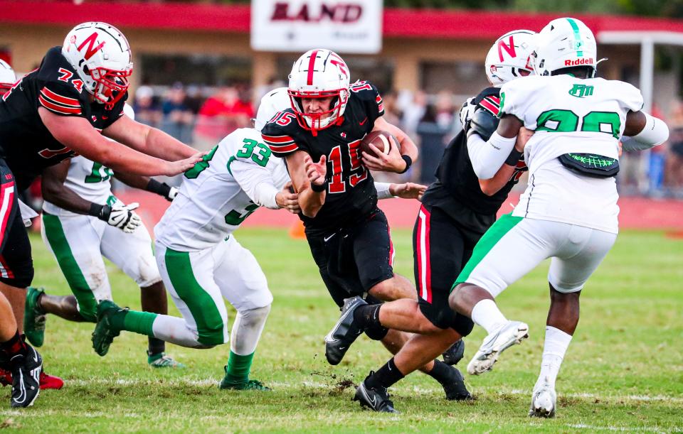 North's quarterback, Bryce Duross, keeps the ball as he gains yards for the Red Knights. Fort Myers takes on North Fort Myers in non-district play, Friday August 26, 2022, at North Fort Myers. 