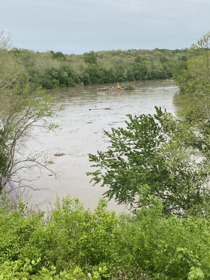 A large barge being used by a National Park Service contractor makes its way down the Potomac River on Sunday after breaking free from its moorings near McMahons Mill during high waters following weekend rains.