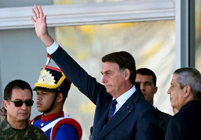 Le président brésilien Jair Bolsonaro (C) salue lors d'un défilé de véhicules militaires devant le palais du Planalto à Brasilia, le 10 août 2021 - EVARISTO SA © 2019 AFP