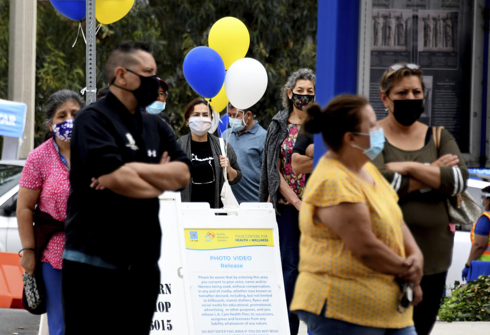 People line up to receive free flu shots during a walk up and drive thru clinic by L.A. Care Health Plan and Blue Shield of California Promise Health Plan's network of Community Resource Centers at Historic General Hospital in Los Angeles on Saturday, October 10, 2020. (Keith Birmingham/The Orange County Register via AP)